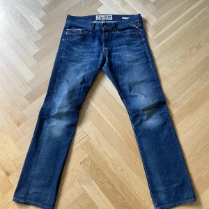 Blå Replay jeansbyxor herr - Säljer ett par klassiska blå jeans från Replay med raka ben och femficksmodell. Byxorna har normal passform och tydliga Replay-detaljer på fickorna. Perfekta för dig som gillar tidlös denimstil.