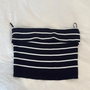 Svartvitrandig ribbad tubtopp från FB Sister - Säljer en svart tubtopp med vita horisontella ränder från FB Sister. Toppen är ribbad och har en croppad passform. Perfekt att styla till jeans eller kjol för en trendig look.