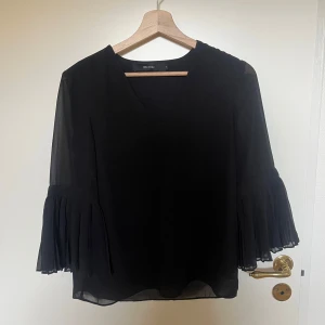 Svart blus med volangärmar från Vero Moda - Säljer en svart blus från Vero Moda med v-ringning och trekvarts volangärmar. Använd fåtal gånger🫶🏼