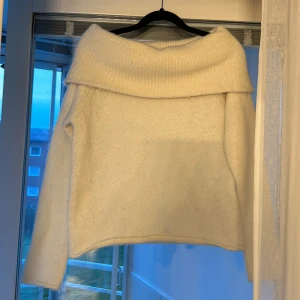 Vit stickad offshoulder-tröja från Gina Tricot - Säljer en vit stickad offshoulder-tröja från Gina Tricot. Tröjan har en bred krage som vilar över axlarna och långa ärmar. Perfekt för dig som gillar en stilren och mysig look. Superfin att matcha med jeans eller kjol!Säljer då jag aldrig använt! Nytt pris på denna var 350-400 kommer inte riktigt ihåg men nått där mellan. Då har jag bestämt mig för att sälja den för 229 eftersom jag aldrig använt den men pris kan diskuteras