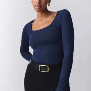 Mörkblå långärmad topp från Gina Tricot - Säljer en mörkblå långärmad topp från Gina Tricot som har slits fram vid handleden 