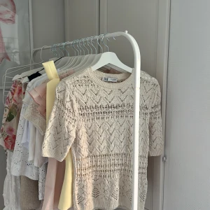 Beige stickad topp från Zara - Säljer en beige stickad topp från Zara med korta ärmar och ett snyggt hålmönster. Säljer tröjan då den inte kommer till användning längre!