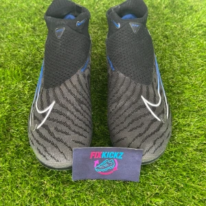 Phantom GX Elite DF FG Shadow -  Produkt: Phantom GX Elite DF FG Shadow Storlek: 45 Skick: Använd vid få tillfällen Nypris: 3300 kr Nike Phantom GX Elite DF FG “Shadow” är en toppklassig fotbollssko designad för spelare som söker precision, komfort och kontroll på naturliga gräsplaner och konstgräs samtidigt.  