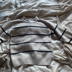Beige stickad tröja med svarta ränder från Gina Tricot - Säljer en beige stickad tröja från Gina Tricot med svarta ränder då den blivit för liten för mig! Den är i strl 158-164 men tycker den är lite större. Använd fåtal gånger