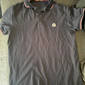 MörkBlå Moncler Piké - Säljer en mörkblå Piké från Moncler. Har använts lagom där av det billiga priset! Vid frågor eller funderingar tveka inte att höra av er! Passar S/M