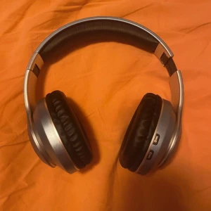 Hörlurar  - Trådlösa hörlurar, modell VJ033.  Hörlurarna har en elegant blå design med texten "MUSIC" på sidan.  Perfekta för musiklyssning på språng.