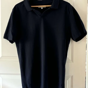 Mörkblå pikétröja från S.C.W. - Klassisk mörkblå pikétröja från S.C.W. i storlek M. T