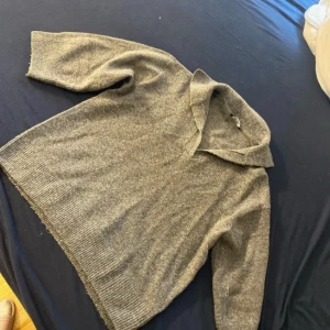 Grå stickad tröja med krage - Mysig grå stickad tröja från Esmara med bred krage och lång ärm. Tröjan har en avslappnad passform och ribbade muddar vid ärmslut och nederkant. Perfekt för kyligare dagar.