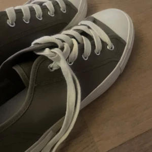 Grå sneakers - Säljer ett par grå sneakers med vita snören. Använda 2 ggr. 
