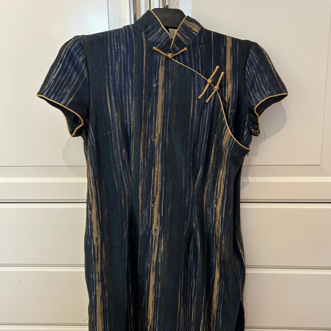 Mörkblå cheongsam-klänning med guldiga ränder från NONGHEMING