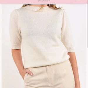  stickad Kashmir topp från Jackie - Säljer en stilren stickad topp från Jackie. Tröjan har korta ärmar, rund halsringning och en mjuk, lätt ribbad struktur. Perfekt att styla med både jeans och kjol för en clean look. Nypris 2200kr