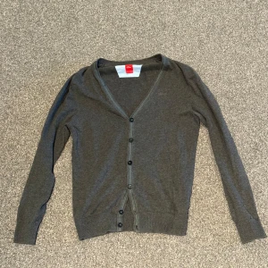 Knapptröja - Snygg grå kofta med gröna detaljer längst med kragen och knapparna