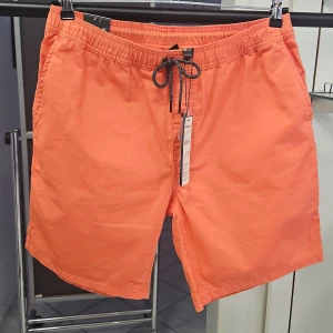 O'Neill orange shorts med snörning - Säljer ett par orange shorts från O'Neill i modellen 'Lm Elas Summer Shorts'. De har elastisk midja med svart snörning, sidofickor och bakfickor. Perfekta för sommaren och tillverkade i ett lätt material. Vintage effekt. Bomull material.