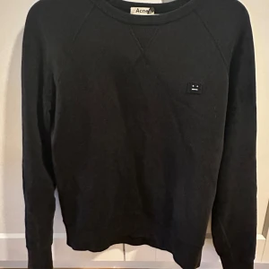 Svart sweatshirt från Acne Studios - En stilren svart sweatshirt från Acne Studios. Nästan nyskick bortsett från ett litet hål som man ser på bild 3, men den sitter på underarmen så det hålet ser man typ aldrig. Nypris är 3500 kr. Perfekt längden är någonstans mellan 172-180!