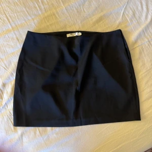 Svart minikjol NA-KD - Svart mini/kortkjol från NA-KD i strl 38! Perfekt för utgång nu i sommar, aldrig använd!! (Nypris 399:-)