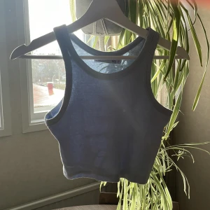 Ljusblå croppad linnetopp från 157 - Säljer en ljusblå croppad linnetopp från 157. Toppen är ribbad och har breda axelband samt rund halsringning. Perfekt för varma dagar eller som lager under en skjorta.