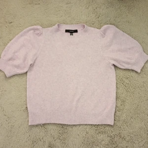 Ljuslila puffärmad tröja från Vero Moda - Supersöt ljuslila tröja från Vero Moda med puffärmar och rund halsringning. Tröjan har ribbade muddar vid ärmslut och nederkant, vilket ger en snygg passform. Perfekt för dig som gillar en feminin och trendig stil!
