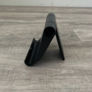 Svart vikbar mobilhållare Västervik - Säljer en svart vikbar mobilhållare i plast. Perfekt för att ställa mobilen på bordet när du kollar på videos eller pluggar. Enkel att fälla ihop och ta med sig i väskan. Stilren och smidig design.