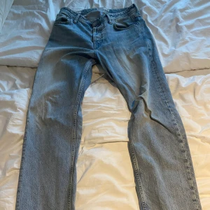 Loose fit ljusblå jeans  - Säljer ett par ljusblå jeans i loose fit-modell. Byxorna har klassisk femficksdesign, knappgylf och raka ben. Perfekt för dig som gillar avslappnad stil och vill ha bekväma jeans med lite extra utrymme.