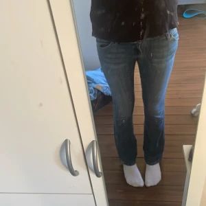 Blå bootcut jeans från Wrangler - Mina favorit jeans säljer då dem tyvärr är försmå. Snygga blå jeans från Wrangler med klassisk bootcut passform och låg midja. Jeansen har slitningar och kontrastsömmar, samt detaljerade bakfickor med broderad W och Wrangler-logga. Jag är 175 för referens och brukar oftast ha Xs/s i byxor. Dessa är lite försmå i midjan. Innerbenslängden är ungefär 83cm. 