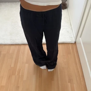 Mörkblå linnebyxor med snörning - Snygga mörkblå linnebyxor med avslappnad passform och raka ben. Byxorna har elastisk midja med snörning och praktiska fickor på sidorna. Storlek s, referens jag är 169 cm lång. Ordinarie pris 500