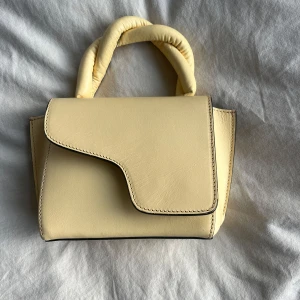 Beige handväska från ATP Atelier - Snygg beige handväska från ATP Atelier med coolt, vadderat handtag och stilren design. Väskan är i väldigt bra skick och har köpt ny för ca 3500kr. Pris kan diskuteras