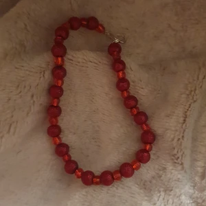 Rött pärlarmband med silverlås - Snyggt armband med röda glaspärlor och små glittriga detaljer. Pärlorna är runda och sitter på rad med ett silverfärgat lås. Perfekt accessoar för att ge din outfit lite extra färg och vibe.