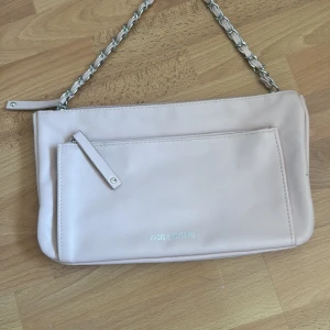 Rosa axelväska från Zadig & Voltaire - Snygg ljusrosa axelväska i skinn från Zadig & Voltaire med silverfärgad kedja som axelrem. Framsidan har en praktisk ficka med dragkedja och diskret logga, baksidan har präglad text 'Girls Can Do Anything'. Den säljs för den aldrig kommit till andvändning! Men är Såå snygg💞🙌