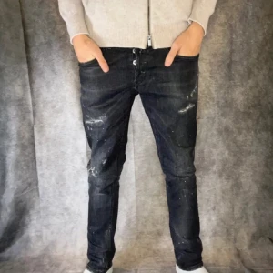 Svarta dondup jeans med slitningar - Snygga svarta dondup jeans med coola färgstänk och slitningar. Jeansen har en mörk tvätt och är gjorda i jeansmaterial med lite stretch för skönare passform. Skriv gärna om det är några frågor, priset kan diskuteras