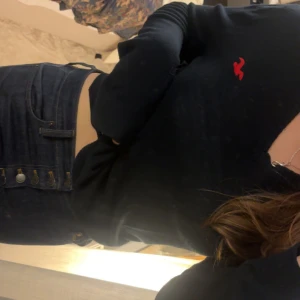 Mörkblå v-ringad tröja från Hollister - Mörkblå/svart långärmad tröja från Hollister med v-ringning och broderad logo på bröstet. Ribbade muddar vid ärmslut och nederkant. Perfekt för dig som gillar elegant och stilrent. 🖤