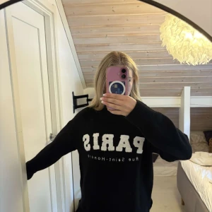 Svart stickad tröja med Paris-tryck - Svart stickad tröja från Primark med stor vit text 'PARIS', passar perfekt en kall höstdag, aldrig använd ☺️