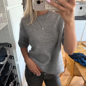 Grå stickad tröja i wool blend Gina tricot  - Mysig grå stickad tröja med korta ärmar och rund hals. Helt ny med prislapp. Wool blend