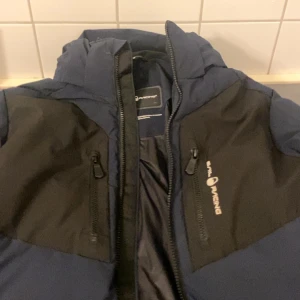 Blå och svart dunjacka från Sail Racing - Säljer en snygg dunjacka från Sail Racing i mörkblå och svart. Säljer pga att den är för stor för mig har ba andvänt få gånger! Kp för mer info❤️