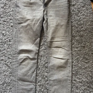 Grå Levi's 502 jeans W30 L34 - Snygga grå jeans från Levi's modell 502 med klassisk femficksdesign och raka ben. Jeansen har en cool tvättad look, läderpatch bak i midjan och den ikoniska röda Levi's-taggen på bakfickan. 