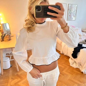 Vit blus med volang och svarta detaljer - söt blus 