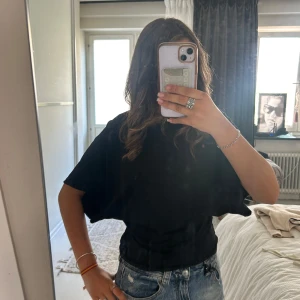 Svart loose t-shirt med kort ärm - Pris kan diskuteras. Använd Max 4 gånger, så inga skador eller något. Precis som ny. Säljer för att den har blivit för stor för mig. Orginal pris 349 kronor. Säljer en svart t-shirt med loose passform och korta, breda ärmar. T-shirten har enkel design utan mönster eller detaljer och är gjord i mjukt material som känns skönt mot huden. Perfekt till jeans eller shorts för en chill look. 🥰🥰