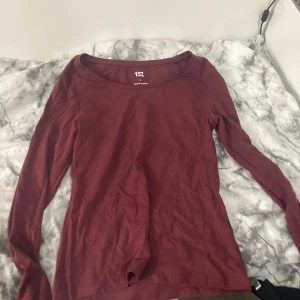 Vinröd långärmad tröja från 157 - Snygg vinröd långärmad tröja från 157 i storlek S. Tröjan har en rund halsringning och är gjord i mjuk bomull med lite stretch för skön passform. Perfekt att matcha med jeans eller kjol för en chill look.