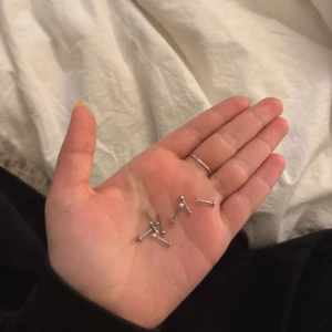 Silverfärgade piercingörhängen - Säljer flera små, raka piercingörhängen i silverfärgad metall. De har en minimalistisk design med en liten kula i ena änden och platt avslutning på andra sidan. Perfekt för dig som gillar enkel och clean stil.