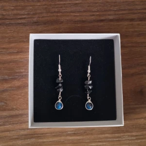 Örhängen med ädelstenar - Helt oanvända handgjorda silverörhängen med pärlor av ädelstenarna blått tigeröga / falköga samt svart obsidian 💙🖤 glänser superfint i ljuset.  Hänget är av sterling silver och resterande metall är silverpläterad koppar.  PS. Har bundle-rabatt!