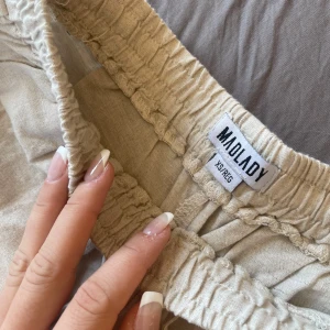 Beige linnebyxor från madlady - Snygga beige linnebyxor från Madlady i storlek XS (regular längd). de har fickor där fram. de är förkorta för mig drf säljer jag dem. för fler bilder är det bara att skriva