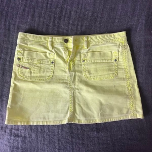 Gul jeanskjol från Diesel - Är utomlands så reserverar kjolen till den första som vill köpa! Postar när jag kommer hem den 14 juli. Snygg och populär gul kort jeanskjol från Diesel med låg midja. Färgen är mer neon än på de första bilderna, verkliga färgen syns på sista bilden. Den vintage och perfekt till sommaren, färgen gör även att man ser väldigt brun ut. Först till kvarn!