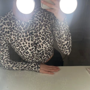 Leopardmönstrad croppad blus - xs, har knappar så man kan justera hur den sitter. Fint skick. Snygg blus. 15kr