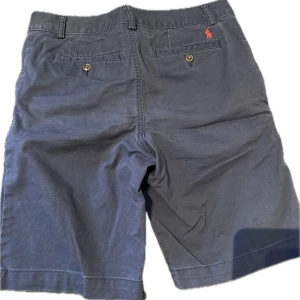 Ralph lauren shorts  - Snygga och klassiska chinosshorts från Ralph Lauren – perfekt för sommaren eller en stilren vardagslook. Tillverkade i högkvalitativ bomull med avslappnad passform och subtil logga broderad ovanför fickan. Lika snygga med en piké som med en enkel t-shirt! Fräscha, bekväma och redo att användas direkt!