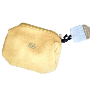 Lyxig Necessär från “Indian Bazaar” – Stil och Funktion i Ett! - ✨ Färg: Elegant ljusgul 👜 Material: Veganskt, miljövänligt och slitstarkt 📏 Storlek: Perfekt för smink, hygienartiklar eller småsaker på resan 🌍 Etisk & Hållbar: Tillverkad med omtanke för både människor och planeten  Elegant necessär från Indian Bazaar Stilren ljusgul väska i veganskt och hållbart material. Perfekt för smink eller småsaker – både hemma och på resan. Begränsat antal – passa på! 