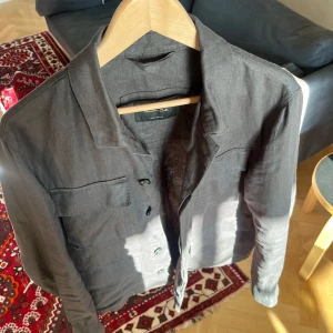  Massimo Dutti linne overshirt - Snygg overshirt från Massimo Dutti i 100% linne. Den har klassisk krage, knäppning framtill och två bröstfickor med lock. Perfekt för en stilren och avslappnad look. Passar lika bra öppen som stängd.