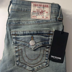 True Religion ljusblå bootcut jeans - Säljer ett par ikoniska ljusblå bootcut jeans från True Religion, säljer för de var dör stora och har aldrig använt pågrund av det, lapparna är fortfarande kvar som bevis på oanvända!
