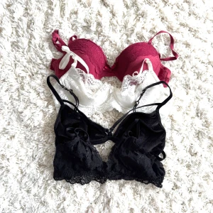 4-pack spetsiga braletter/bhar - Säljer ett set med 4 bhar. En vinröd med rosett och spetsdetaljer 70B, en vit med spetskant 70B, en svart i i ”sammet” small och en svart med tunna band och spets xs. Alla har justerbara axelband och fina spetsmönster. Perfekt för dig som gillar söta och feminina underkläder.