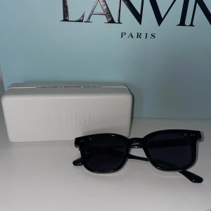 Svarta CHIMI 02 - Stilrena svarta 02 solglasögon från CHIMI med klassisk, fyrkantig form och glansig finish. Kommer med originalvitt CHIMI-fodral. ÄKTA!✨