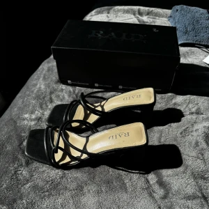 Svarta klackar - Stilrena svarta sandaler från RAID med fyrkantig tå och höga blockklackar. 