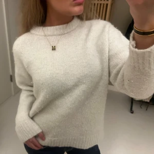 Vit stickad tröja med rund hals - Mysig vit stickad tröja med rund halsringning och ribbade muddar. Tröjan har en relaxed passform och långa ärmar, perfekt för lager på lager. Enkel och stilren design som funkar till jeans eller kjol❤️